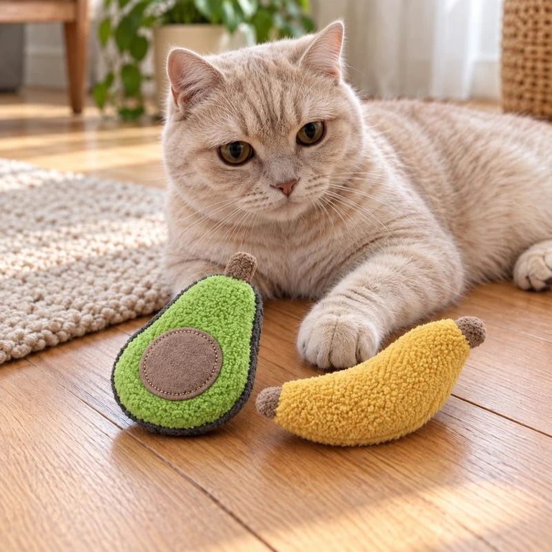 Upright-eared cream cat with avocado and banana catnip toys